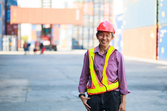 Portrait asian Senior dock worker working at Cargo container yard. Marine and carrier insurance concept. cargo shipping container box in logistic shipping yard