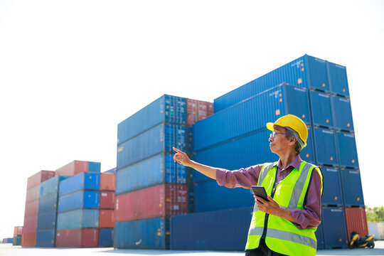 Senior dock worker working and use smartphone at Cargo container yard. Marine and carrier insurance concept. cargo shipping container box in logistic shipping yard
