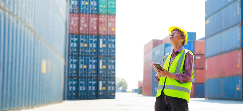 Senior dock worker working and use smartphone at Cargo container yard. Marine and carrier insurance concept. cargo shipping container box in logistic shipping yard