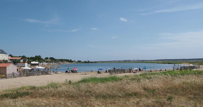 Artificial swimming basin at Marennes-Plage in Charente Maritime, surrounded by a dune system and marshes, with a view of the Seudre viaduct between La Tremblade and Ronce-les-Bains.
