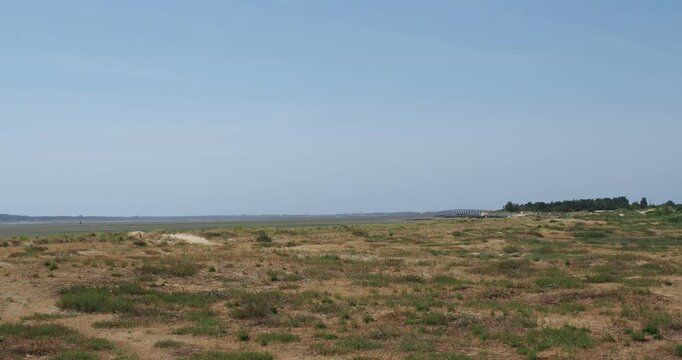 Sand dunes and marshland stretching as far as the eye can see to the Brouage marshes north of Marennes-Plage in Charente-Maritime, with a view of the Pont d'Ol&eacute;ron.