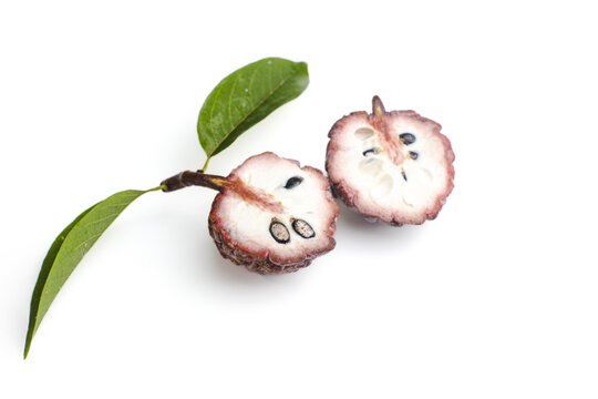Fresh sugar apple fruit cut in half with leaves isolated on white background