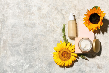 Composition with cosmetic products, sunflowers and branch of rosemary on grunge background © Pixel-Shot
