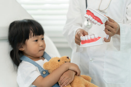 Dentist or dentist treating and advice little girl teeth, Child receiving treatment from dentist, medicine, dentistry and healthcare, annual checkup, fluoride coating, tooth decay