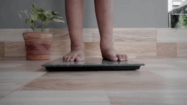 Pree school boy measuring weight on digital scale