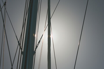 Obraz premium Sailboat masts and rigging against bright sky in Caribbean sea