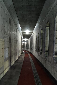 Path through Dark Concrete Tunnel with Electric Lighting