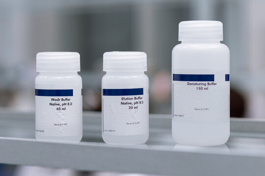 Three bottles of reagents for working with DNA molecules in the lab. A DNA extraction kit.
