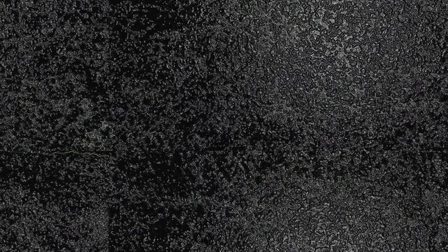 Dark abstract texture with glowing organic patterns, dense speckles, shadows, and subtle depth. Grunge texture background animation.