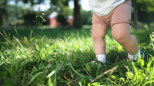 Parents cheer as son takes step. Mom father encourage son first step park. Son takes confident step with support from mom father. Joyful moment as son steps forward. Family celebrates milestone step.