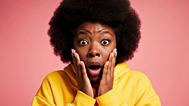 Shocked Young Black Woman with Afro Expressing Intense Surprise in Yellow Hoodie