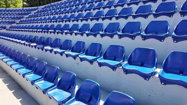 Rows of empty blue stadium seats creating a repeating geometric pattern, suitable for sports, events, attendance and venue concepts