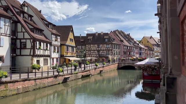 A canal with old colorful houses in France. Summer sunny day in Colmar.