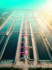 Obraz premium Rectangular water treatment basins and pink pipes arranged in parallel rows at dusk for environmental reports, infrastructure development and industrial design presentations