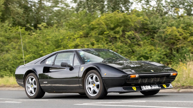 Stony Stratford,Bucks,UK - June 7th 2026:  1976 black Ferrari 308 classic car driving on a British road