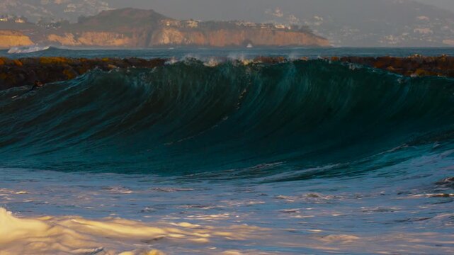 Huge waves breaking on the beach at sunset in Newport beach