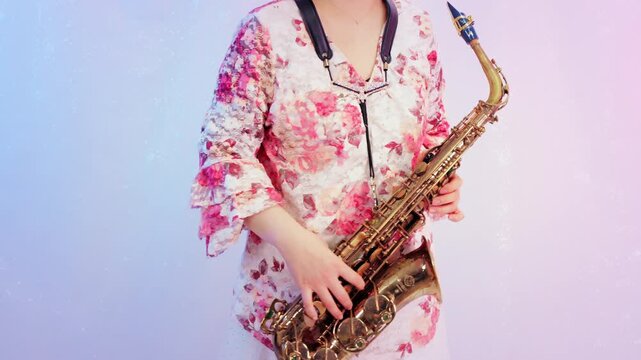 アルトサックスを持って立っている女性:白背景