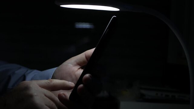 Blurred Shooting with a Person Making a Phone Call Using a Smartphone. Businessman Texting on a Cellphone Using Internet Connection. Chatting a Person with Mobile Using Digital Communication.