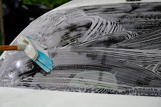 washing car windows with a brush
