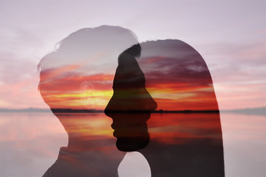 Silhouettes of man and woman against seascape at sunset. Love, bonding, relationships