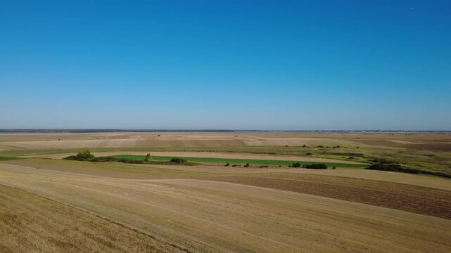 Panoramic Drone Shot Over Summer Farmland. Stunning Drone Aerial of Cultivated Fields and Green Vegetation.