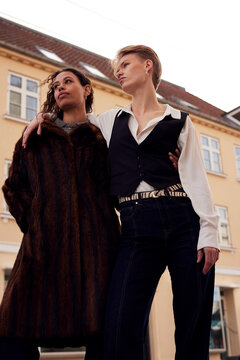 Two diverse women Standing Together Outside a Cafe in Stylish Outfits, Fashion and Friendship