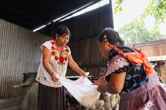 Women collaborating to create corn atole