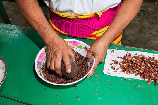 Woman Grinding cacao Beans with Stone Tool