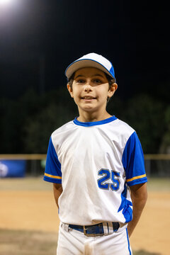 Young Player Poses During a Night Baseball Game