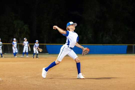 Baseball Player Throwing Ball at Night During Game