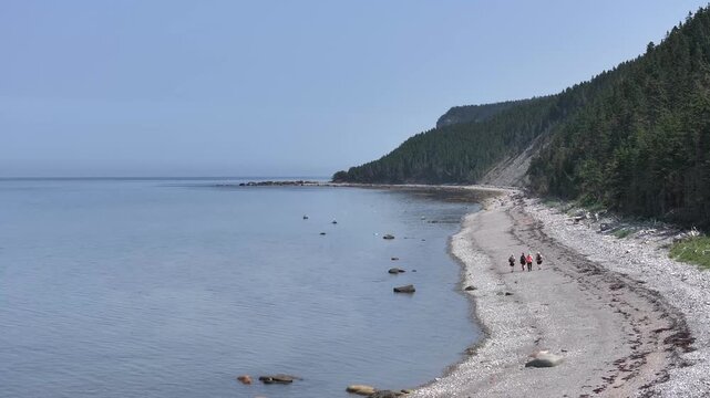 People walks in a Dirt and Stone Road Between the Forest and the River near the Waterfall Known as "Chute &agrave; Boule" in Anticosti Island, Quebec, Canada