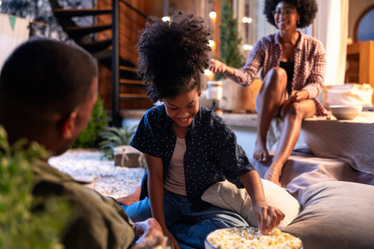 Family talking together with popcorn on patio under string lights