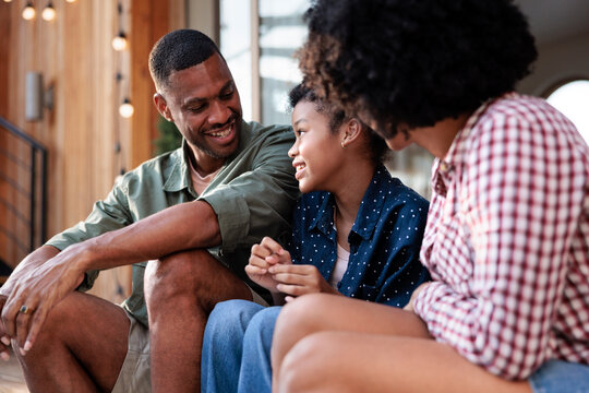 Happy family moment, father, mother, and daughter smiling.