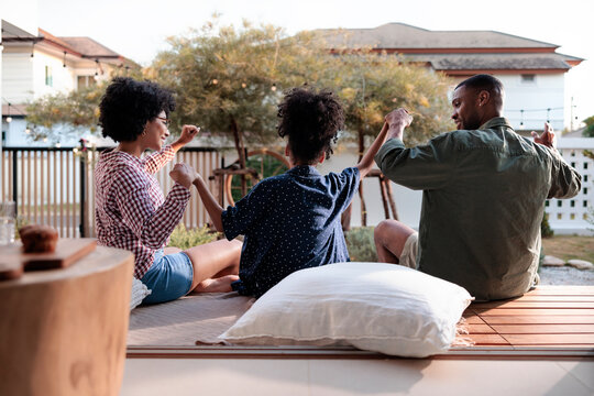 Family holds hands, enjoying time together on the patio.