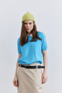 Portrait Woman in Blue Top and Beanie Over White Background