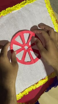 Young boy attaching a handcrafted dharma chakra to a Vesak lantern, reflecting Buddhist values, spiritual symbolism, and cultural celebration.