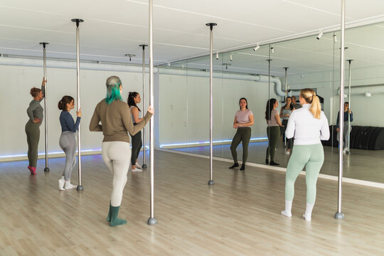 Group of women standing in pole dance studio