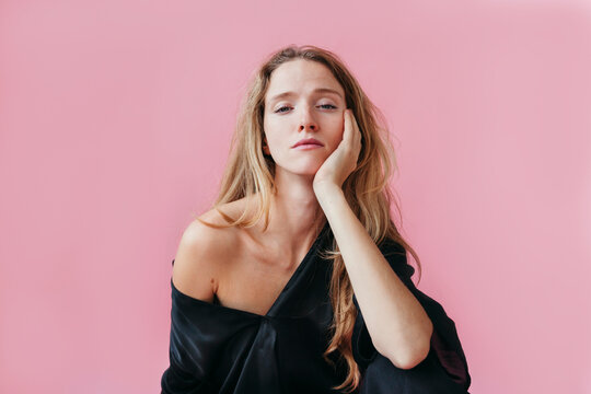 Natural Beauty With a Calm Expression Against a Pink Backdrop
