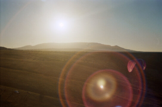 Paraglider in the sunset light over the mountains.