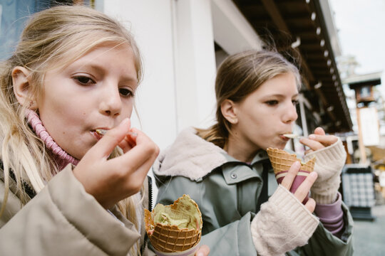 Two girls eating ice-cream outdoors