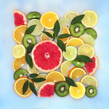 Healthy citrus fruit and leaf abstract food art design. Summer tropical colorful square shape on blue sky cloud background. High in antioxidants and vitamin c.