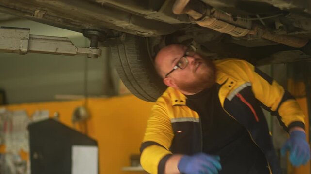 Caucasian male mechanic with glasses and a beard works alongside a female technician, reviewing a digital tablet and giving a thumbs-up. This high-energy commercial imagery represents gender diversity