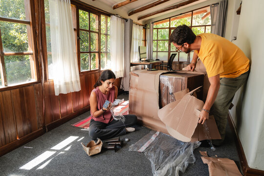 Young Couple Unboxing New Furniture Delivery at Home
