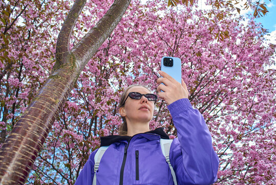 Low angle shot of woman taking photo with smartphone
