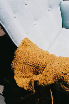Cozy armchair with warm knitted blanket draped