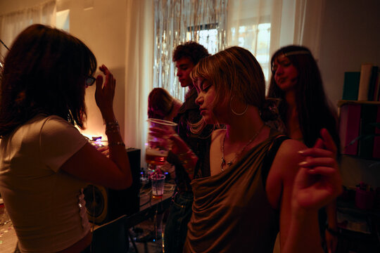 Friends dancing together at cozy apartment party