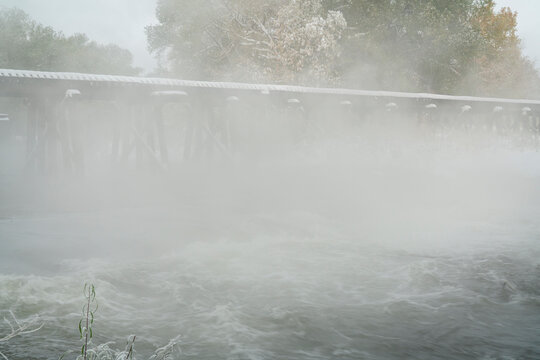railroad trestle over foggy river with fresh snow - Poudre River in Fort Collins, Colorado