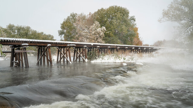 railroad trestle over foggy river with fresh snow - Poudre River in Fort Collins, Colorado