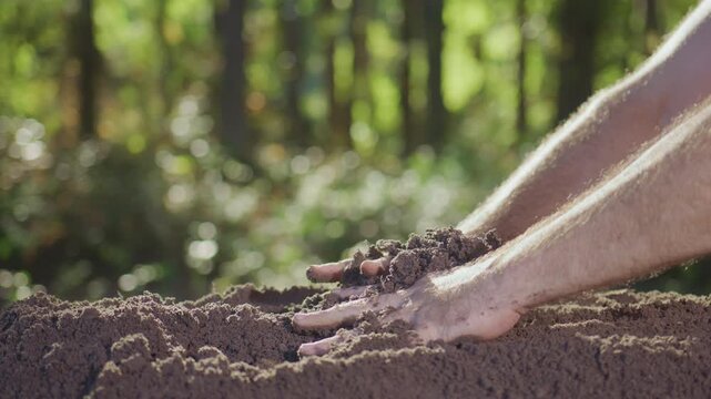 Earth and ecology theme video. Closeup of dirt and clay in hands. Man handling soil. Cultivated land. Melioration concept. Fertile soil and humus in farmers hand. Close up of hands holding soil.