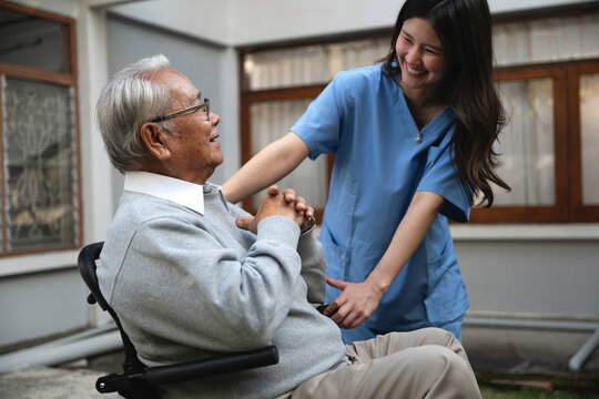 Happy elderly retired grandfather smiled on wheelchair with caregiver patient backyard, professional caregiver wellness support older people relationship portrait, retired life grandfather recovery.